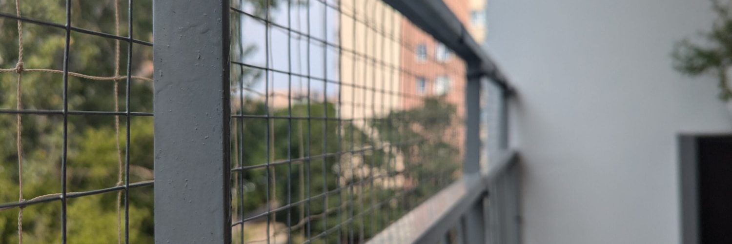 siatka metalowa i polietylenowa Widok na balkon z siatką z tworzywa i metalowym wzmocnieniem na dole.